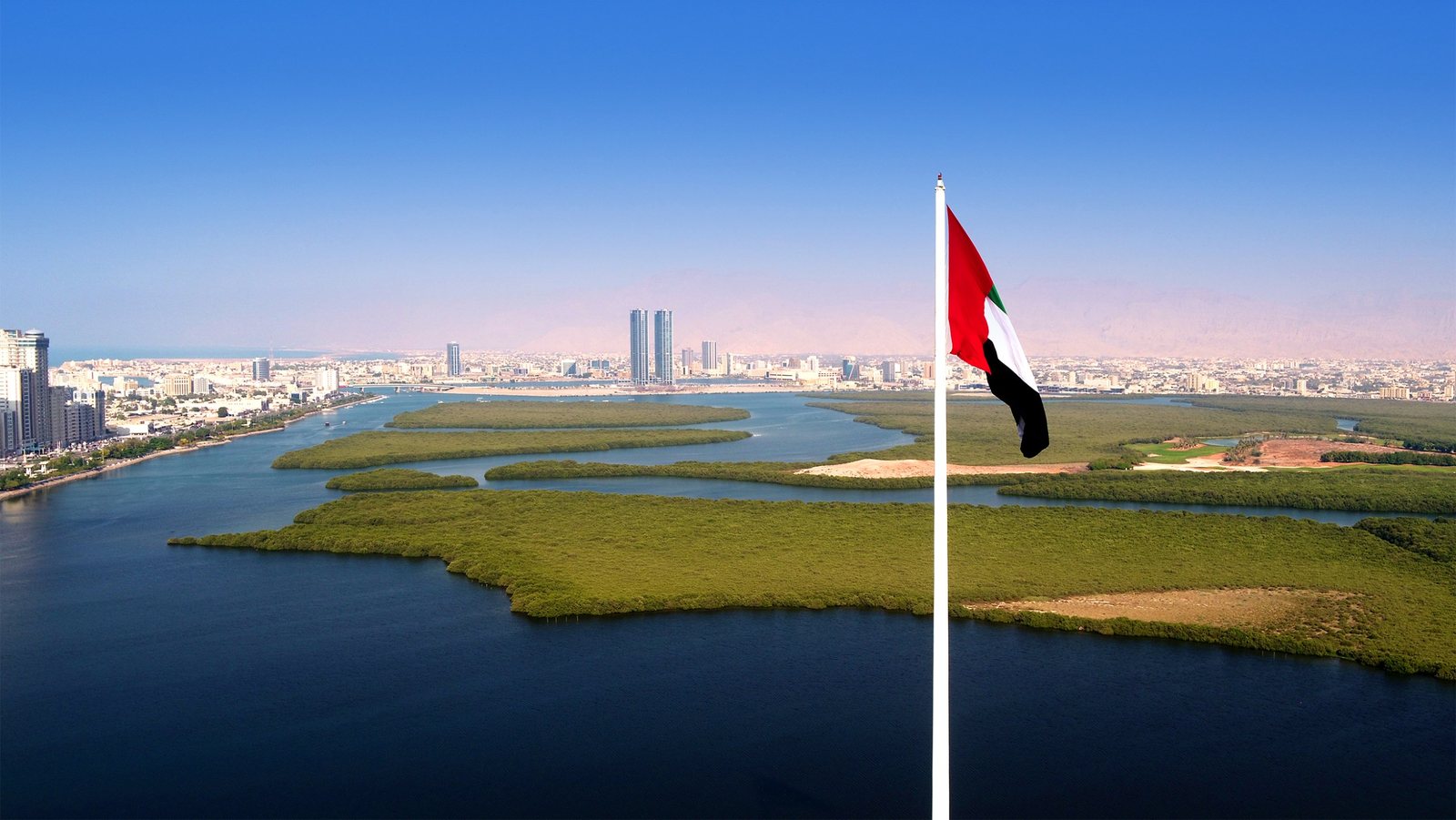 Aerial view of Ras Al Khaimah with mangroves, the creek, the city and the Hajar mountains